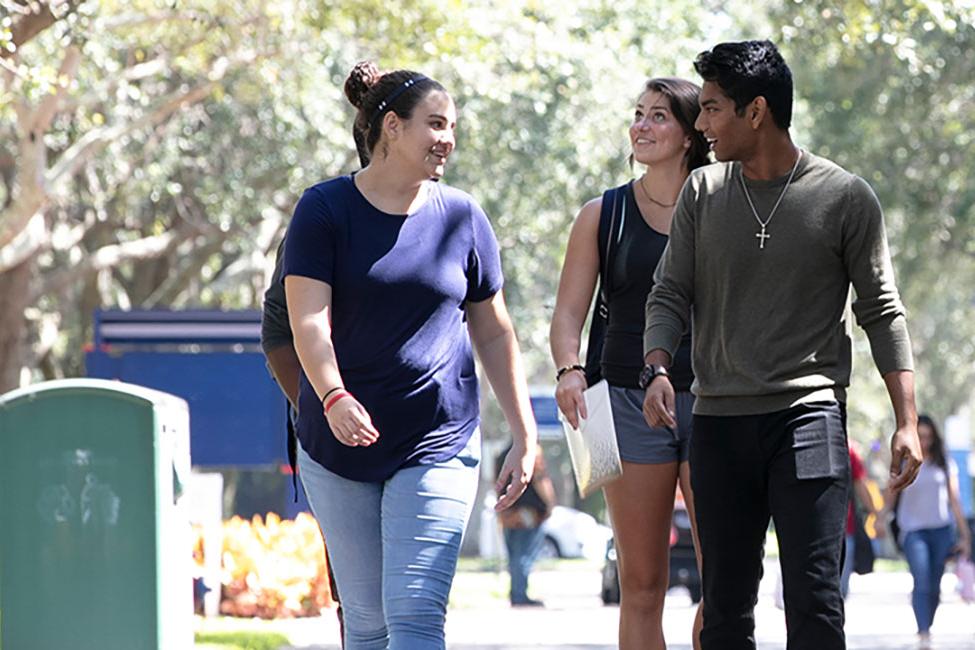 three students walking and looking at each other